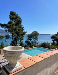 ラ・セーヌ・シュル・メールにあるVilla Les Terrasses Tamaris Les Sablettesのプールの横の壁に置かれた石のプランター