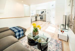 ロサンゼルスにあるUnique 3-Level Loft with One bedroom & Two Full Bathroomのソファとガラスのテーブルのあるリビングルーム +15枚の写真