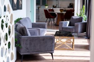 a living room with three chairs and a table at Thome Vlaicu170 Jacuzzi in Cluj-Napoca