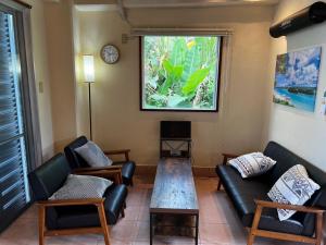 a living room with couches and a table and a window at OceanViewHouseAmala in Fukai