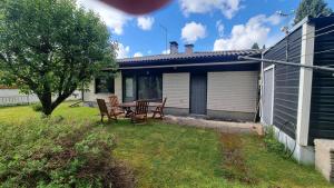 a patio with a table and chairs in a yard at 3 bedrooms, sauna and kitchen All house in Pori