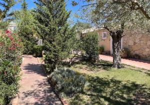 a house with a yard with trees and a sidewalk at Vi Ja Villa Janas Cagliari Resort in Cagliari +37 photos