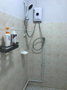 een douche met een douchekop in de badkamer bij Grace Hostel in Khon Kaen