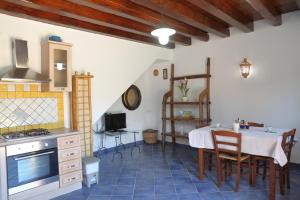 a kitchen and dining room with a table and chairs at Case Vacanze Casa Romana in Lascari