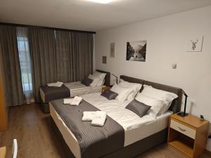 two beds in a hotel room with towels on them at Vivo Bovec in Bovec
