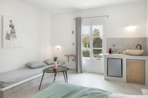 a bedroom with a bed and a table and a kitchen at Irini's Poiēma in Lefkes