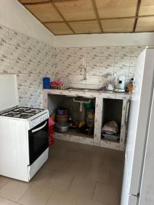 eine Küche mit einem weißen Herd und einem weißen Kühlschrank in der Unterkunft Maison de vacances Calavi séminaire in Abomey-Calavi + 5 Fotos