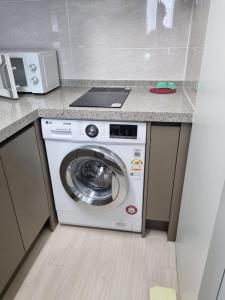 eine Küche mit einer Waschmaschine unter der Theke in der Unterkunft Sokcho Koaroo Arista in Sokcho