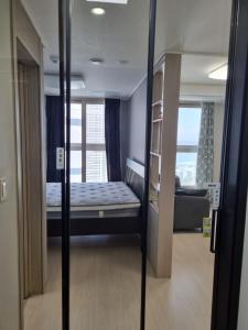 ein kleines Zimmer mit einem Bett und einem Fenster in der Unterkunft Sokcho Koaroo Arista in Sokcho