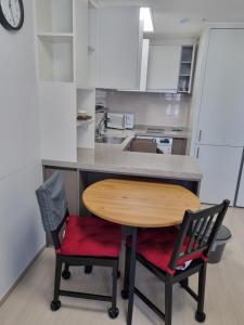 eine Küche mit einem Holztisch und zwei Stühlen in der Unterkunft Sokcho Koaroo Arista in Sokcho + 2 Fotos