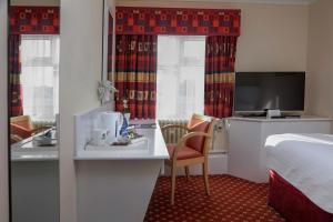 a hotel room with a bed and a desk and a kitchen at Belvilla Crewe Arms Hotel in Crewe