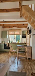 a kitchen with wooden floors and a table and chairs at Agroturystyka Stara Huta - Domek Boho in Narol