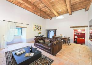 sala de estar con sofá de cuero y mesa en Castello Di Postignano Relais, en Sellano