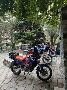 two motorcycles parked next to each other on a sidewalk at Dim's Hotel & Restaurant in Korçë