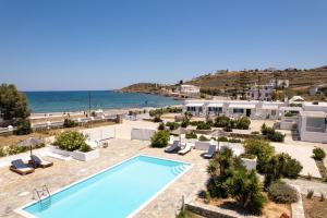 una piscina junto al océano con edificios en Naoussa Hotel Paros by Booking Kottas en Náousa