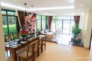 - une salle à manger avec une table et des fleurs dans l'établissement Villa A16 Bách Thanh view hồ - Đại Lải resort, à Phúc Yên