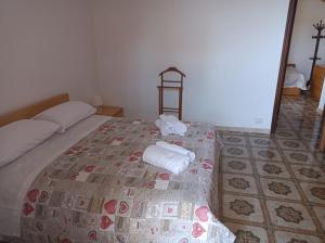 a bedroom with a bed with two towels on it at Villa Nicole in Leporano Marina