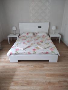 a bedroom with a white bed with two tables at Ainaži in Ainaži