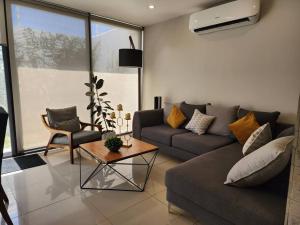 ein Wohnzimmer mit Couch und Tisch in der Unterkunft Amplitud y Confort al Sur de Guadalajara in Los Gavilanes