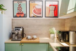 a kitchen with a coffee maker and pictures on the wall at Apartamenty Lighthouse - Premium Dźwirzyno in Dźwirzyno