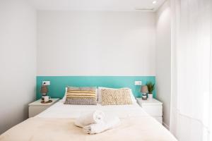 een slaapkamer met een bed met handdoeken erop bij Apartamentos Turísticos Metropolis in Cartagena
