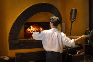 a man standing in front of a brick oven at Tower Club at lebua in Bangkok