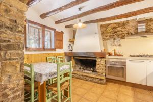 a kitchen with a table and a fireplace at Can Favo in Copóns