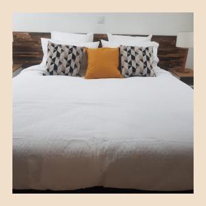 a large white bed with pillows and a white comforter at Maison d hôtes et table gourmande Au vert des lys in Haverskerque