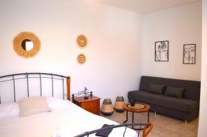 a bedroom with a bed and a couch at Almyra Studio in Posidhonía