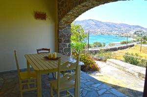 a table and chairs on a patio with a view of the ocean at Almyra Studio in Posidhonía