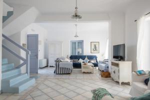 a living room with a blue couch and a tv at Archipelagos Villas-Villa Antiparos in Santa Maria