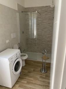 a bathroom with a washing machine and a toilet at La mia Marì in Palestrina +8 photos