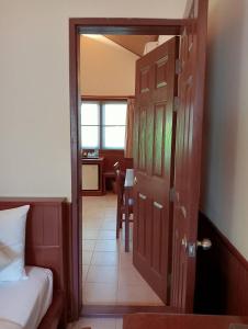 a door to a room with a bed and a desk at Pinnacle Samui Resort in Mae Nam