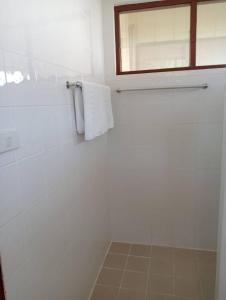 a white bathroom with a towel hanging on a wall at Pinnacle Samui Resort in Mae Nam