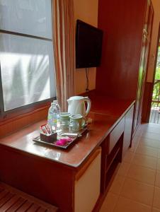 a kitchen with a wooden counter top with a television at Pinnacle Samui Resort in Mae Nam