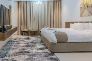 una camera d'albergo con letto, tavolo e TV di السمو ALSMOU للشقق الفندقية a Nizwa