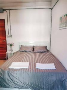 a bed in a room with two white towels on it at Jira19Hostel in Bangkok +4 photos