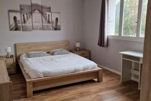 Un dormitorio con una cama con un cuadro en la pared. en Refuge Urbain Chic avec Balcon, en Saint Lo