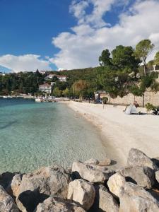 a person sitting on a beach with rocks at Apartman Harmony in Kastav