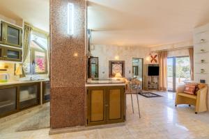 a kitchen and living room with a large column at Paco's Resort Luxury House 16 in Oziás