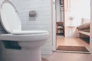 a bathroom with a toilet with the lid up at Jira19Hostel in Bangkok