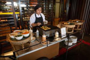 a woman standing in a kitchen preparing food at lebua at State Tower in Bangkok
