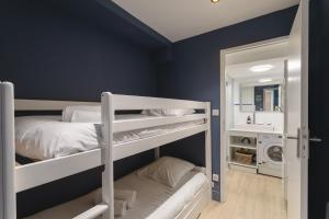 ein Schlafzimmer mit zwei Etagenbetten und einem Spiegel in der Unterkunft Bagatelle - Appt à 300 m de la plage in Dinard