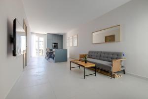 ein Wohnzimmer mit Couch und Tisch in der Unterkunft Chic Penthouse Steps from the Promenade in Gżira