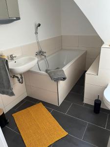 a bathroom with a tub and a sink and a toilet at Seyfarthrooms - Crimmitschau 4 - 110qm, über 2 Etagen, zentral gelegen in Crimmitschau