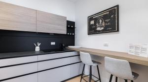 een keuken met witte kasten en 2 krukken bij Aliprandi 29 in Monza