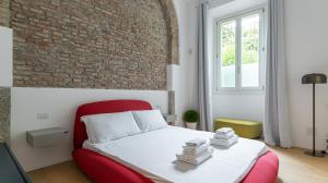 een slaapkamer met een rood bed en een bakstenen muur bij Aliprandi 29 in Monza