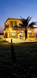 un edificio con una palmera delante en Farm Villa, en Al Rama