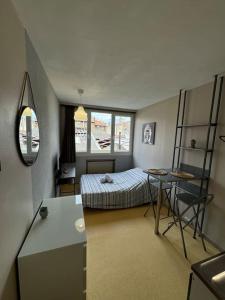 a bedroom with a bed and a table and a desk at Appartement au centre de Valence Studio 5 in Valence