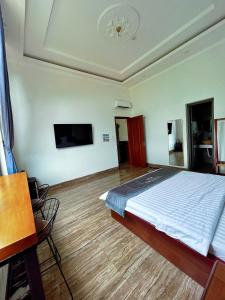 a bedroom with a bed and a flat screen tv at Hotel Luxstay in Pleiku